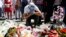 A man reacts near bouquets of flowers as people pay tribute near the scene where a truck ran into a crowd at high speed killing scores and injuring more who were celebrating the Bastille Day national holiday, in Nice, France, July 15, 2016. 