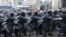 A line of Ukranian riot police moves past protesters in Independence Square in Kyiv.