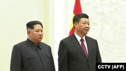 Северокорейский лидер Ким Чен Ын и глава Китая Си Цзиньпин (справа).
