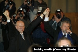 Казулін і Мілінкевіч разам падымаюць рукі ў жэсты адзінства падчас сустрэчы з выбаршчыкамі напярэдаднi прэзiдэнцкiх выбаараў ў Менску, 17 сакавіка 2006 года