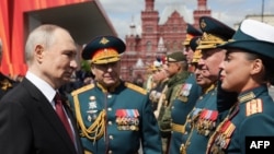 In a photo distributed by Russian state agency Sputnik, Russian President Vladimir Putin greets military commanders after the Victory Day military parade on Red Square in Moscow on May 9.