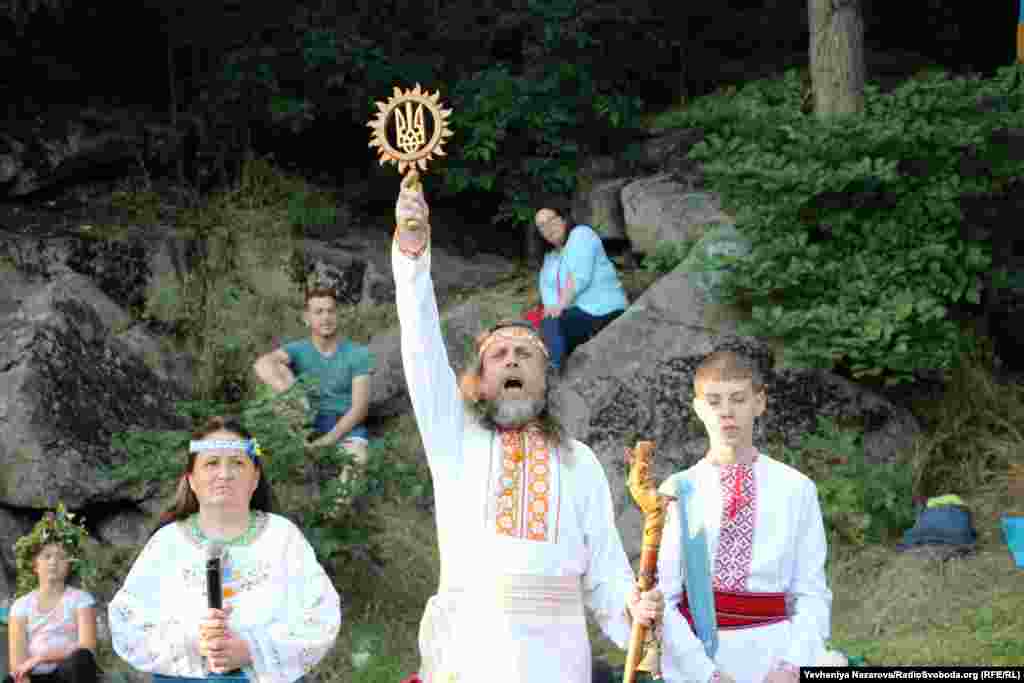 A reveler holds up a symbol of Ukraine.&nbsp;