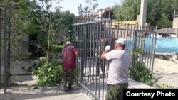 Асыранкулов көчөсүндөгү үйдүн темир тосмосу алынып жаткан учур. Ош, 9-август, 2018-жыл.