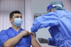 Мужчина получает дозу вакцины AstraZeneca против COVID-19 в больнице в Кишиневе, Молдова, 2 марта 2021 года