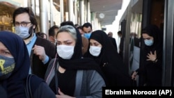 Люди в масках выходят из общественного транспорта в Тегеране. Октябрь 2020 года.