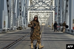 Сотрудник пограничной службы «Талибана» идёт по мосту, который соединяет афганский город Хайратон и Термез в Узбекистане