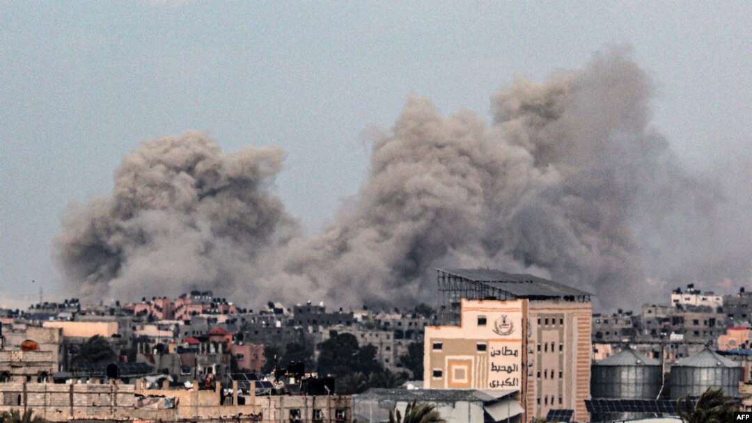 O fotografie realizată din Rafah, în sudul Fâșiei Gaza, arată fumul care se ridică deasupra clădirilor din Khan Yunis, în depărtare, în urma bombardamentelor israeliene din 5 februarie 2024, în timp ce luptele dintre Israel și gruparea palestiniană Hamas continuă.
