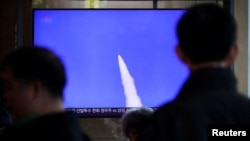 مردم در ایستگاه راه‌آهن سئول، کره جنوبی، در حال تماشای گزارش خبری از شلیک موشک‌های بالستیک کوتاه‌برد کره شمالی از تلویزیون هستند