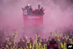 Futbollistët kampionë duke lëvizur nëpër qytetin e Liverpulit me autobus të hapur.