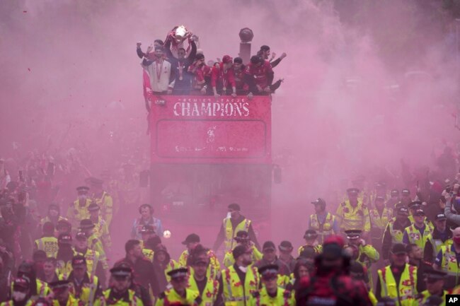 Futbollistët kampionë duke lëvizur nëpër qytetin e Liverpulit me autobus të hapur.