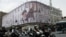 People ride motorcycles near a Tehran billboard with an image of Iran's late supreme leader, Ayatollah Ali Khamenei. 
