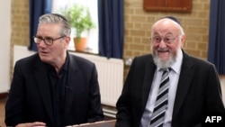 کی‌یر استارمر، نخست‌وزیر بریتانیا، (چپ) در کنار رَبای افرایم میرویس‌، خاخام اعظم بریتانیا در کنیسۀ کنتون