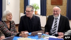 کی‌یر استارمر نخست‌وزیر بریتانیا در کنار ربای افرایم میرویس‌ (چپ) خاخام اعظم بریتانیا در کنیسۀ کنتون در محلۀ هرو