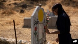 لیلا تالو، یک بازماندهٔ ایزدی، بر مزار یک زن ایزدی دیگر که پس از اسارت توسط داعش، جان خود را از دست داد، ۱۳ سپتامبر ۲۰۱۹