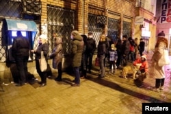 People stand in line to use an ATM in Donetsk before the evacuation.