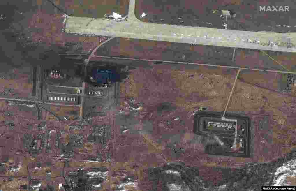 Снимки 24 февраля показывают разрушенное хранилище топлива и другие постройки на военно-воздушной базе в восточной Украине в городе Чугуев в Харьковской области