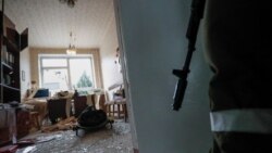 Naoružani militant stoji u blizini tijela službenika škole, koji je prema riječima lokalnog stanovništva poginuo u nedavnom granatiranju, u gradu Horlivka pod kontrolom separatista u Donjeckoj oblasti, Ukrajina, 25. februar