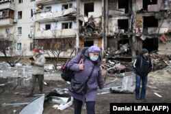 Женщина возле разрушенного дома в Киеве