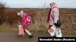 Egy nő és egy gyermek érkezik Ukrajnából Magyarországra Beregsuránynál 2022. február 25-én