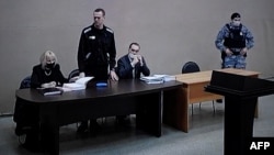 A video feed from the penal colony shows Aleksei Navalny (standing) during the court hearing in the town of Pokrov last month.