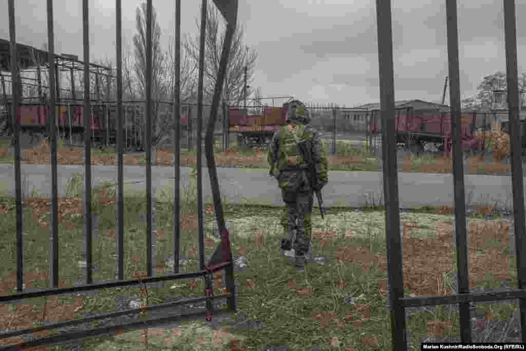 Военнослужащий десантно-штурмовой бригады ВС Украины проходит через ограждение у передовых позиций в Новолуганском