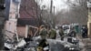 25 февраля 2022 года. Украинские военнослужащие работают у обломков неопознанного самолета, врезавшегося в частный дом в одном из жилых районов Киева