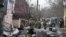 25 февраля 2022 года. Украинские военнослужащие работают у обломков неопознанного самолета, врезавшегося в частный дом в одном из жилых районов Киева