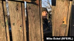 59-годишният бивш миньор Олександър наднича през портата на двора си в село Зайцево
