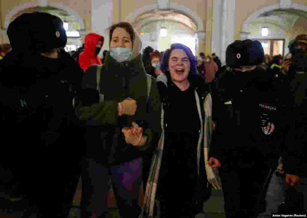 Protestors are led away by police in St. Petersburg.&nbsp;