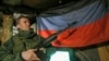 Сепаратистки боец позира пред знамето на самопровъзгласилата се "Донецка народна република"