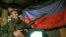 Сепаратистки боец позира пред знамето на самопровъзгласилата се "Донецка народна република"