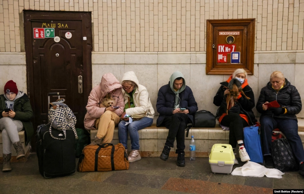 Disa persona qëndrojnë në stacionin e një metroje në Kiev, nga frika e sulmeve ajrore ruse.