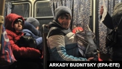 Жители "ДНР"ожидают автобус для въезда в Россию на таможенном посту "Матвеев Курган" в Ростовской области, конец 18 февраля 2022 года. 