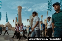 A policeman flanks a procession of karnay horn players during the Silk and Spices festival in Bukhara in 2016.