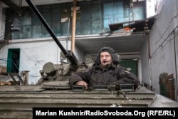 A soldier from a unit of Ukraine's airborne assault brigade sits in a light tank in a warehouse serving as a forward position in Novoluhanske.
