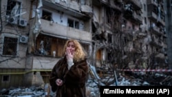 Natali Sevriukova duke qarë pranë shtëpisë së saj të shkatërruar nga një sulm rus me raketa në qytetin e Kievit, Ukrainë, të premten e 25 shkurtit të vitit 2022. 