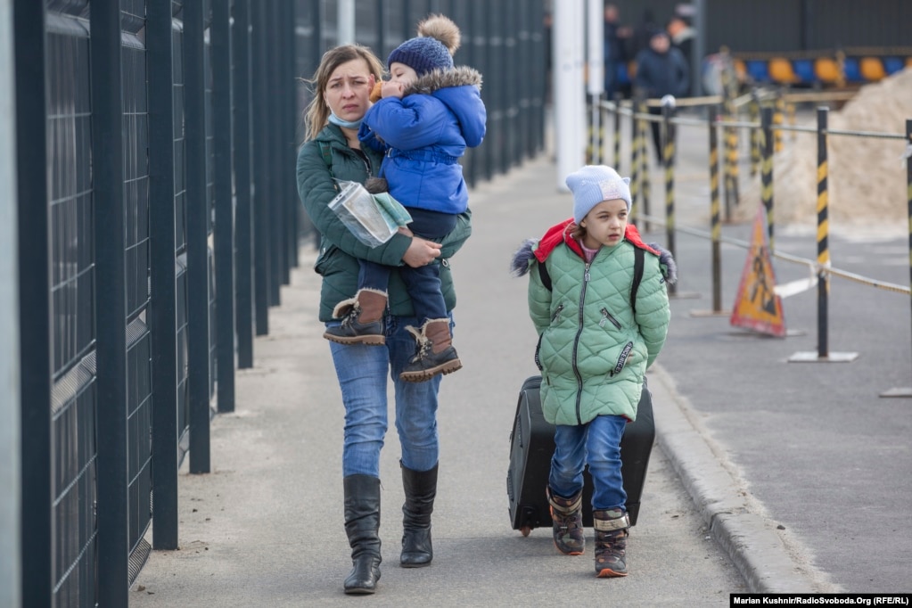 A woman who gave her name only as Iryna crosses the administrative border checkpoint at Stanytsya Luhanska with her son and daughter on February 20.