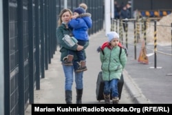 A woman who gave her name only as Iryna crosses the administrative border checkpoint at Stanytsya Luhanska with her son and daughter on February 20.