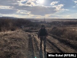  Украински боец върви към позицията си в село Зайцево 