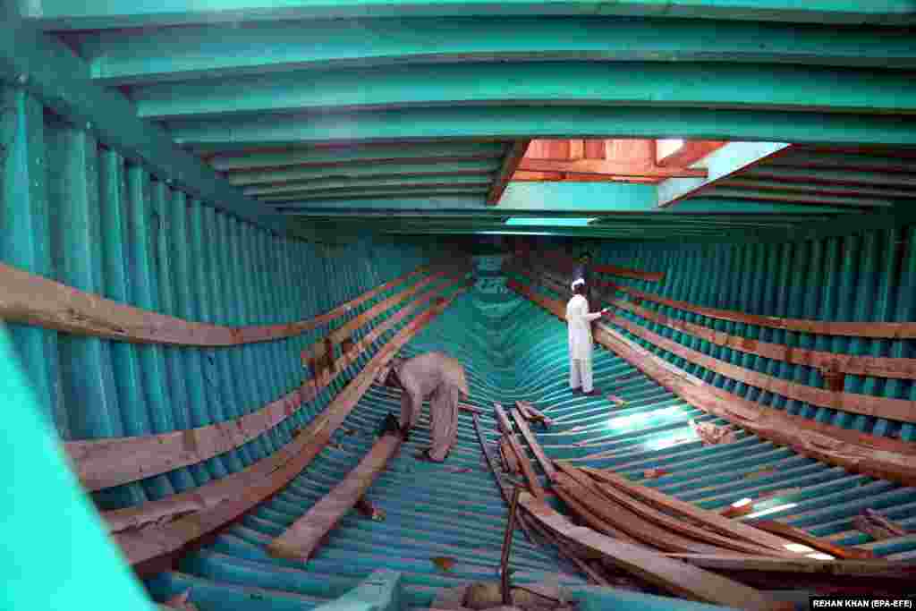 Meșteri pakistanezi construiesc o barcă la șantierul naval din orașul-port Karachi.