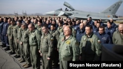 Piloți și soldaț în fața unui avion cu reacție Eurofighter Typhoon al Forțelor Aeriene Spaniole, în timpul unei ceremonii de certificare la baza aeriană Graf Ignatievo, Bulgaria, 17 februarie 2022