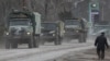 Russian Army military vehicles drive along a street in Armyansk on February 24.