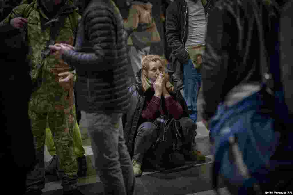 A woman reacts as she waits for a train as she tries to leave Kyiv.&nbsp;