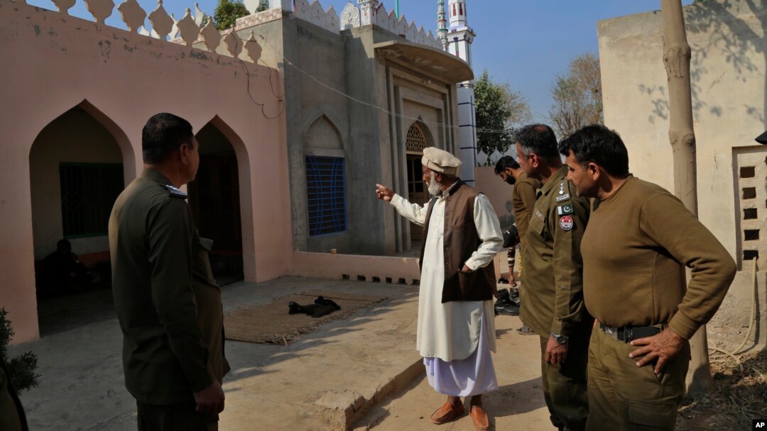 A mosque custodian briefs police officers about the mob lynching attack on Muhammad Mushtaq in Khanewal, eastern Pakistan.