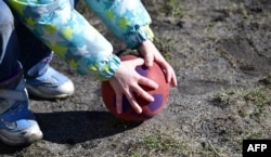 Дитина грається м'ячем у Берліні, Німеччина, 19 березня 2018 року