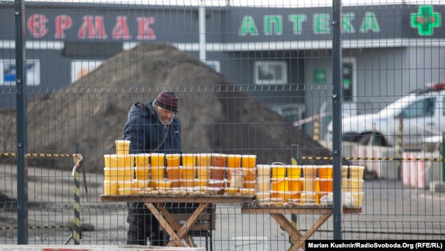Un apicultor vinde miere, ceară de albine și alte produse apicole în punctul de control.