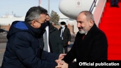 В международном аэропорту Нур-Султана премьер-министра Армении Никола Пашиняна (справа) встречает вице-премьер Казахстана Ермек Кизатов, 24 февраля 2022 г.