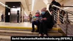 Перші обстріли Києва. Жінка з дитиною ховається в підземному метро, Київ, 24 лютого 2022 року