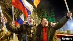 Oroszbarát aktivisták ünnepelnek Donyeck városában, miután Vlagyimir Putyin orosz elnök bejelentette, hogy Oroszország elismeri a szakadár luhanszki és donyecki köztársaság függetlenségét 2022. február 21-én