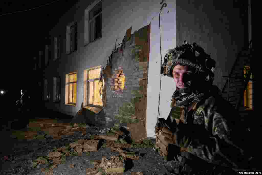 A Ukrainian soldier stands near the site of a shelling of a kindergarten in the Ukrainian settlement of Stanytsia Luhanska​ on February 17.&nbsp;